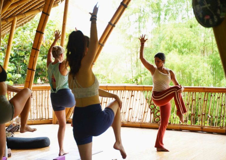 Students practicing yoga in the bamboo shala at Power of Now Oasis in Sanur Bali