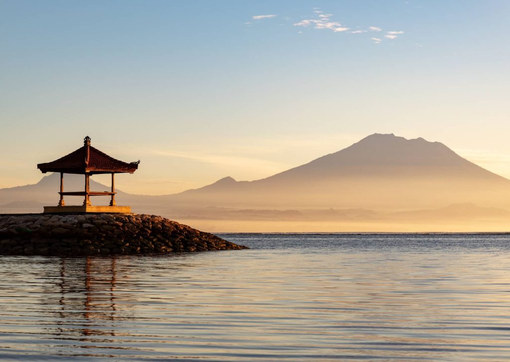 Things to do in Sanur Bali beachfront sunrise walk with a sea pavilion and Mount Agung in the distance