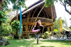 yoga woman in front of tropical yoga shala doing Yoga teacher training in bali