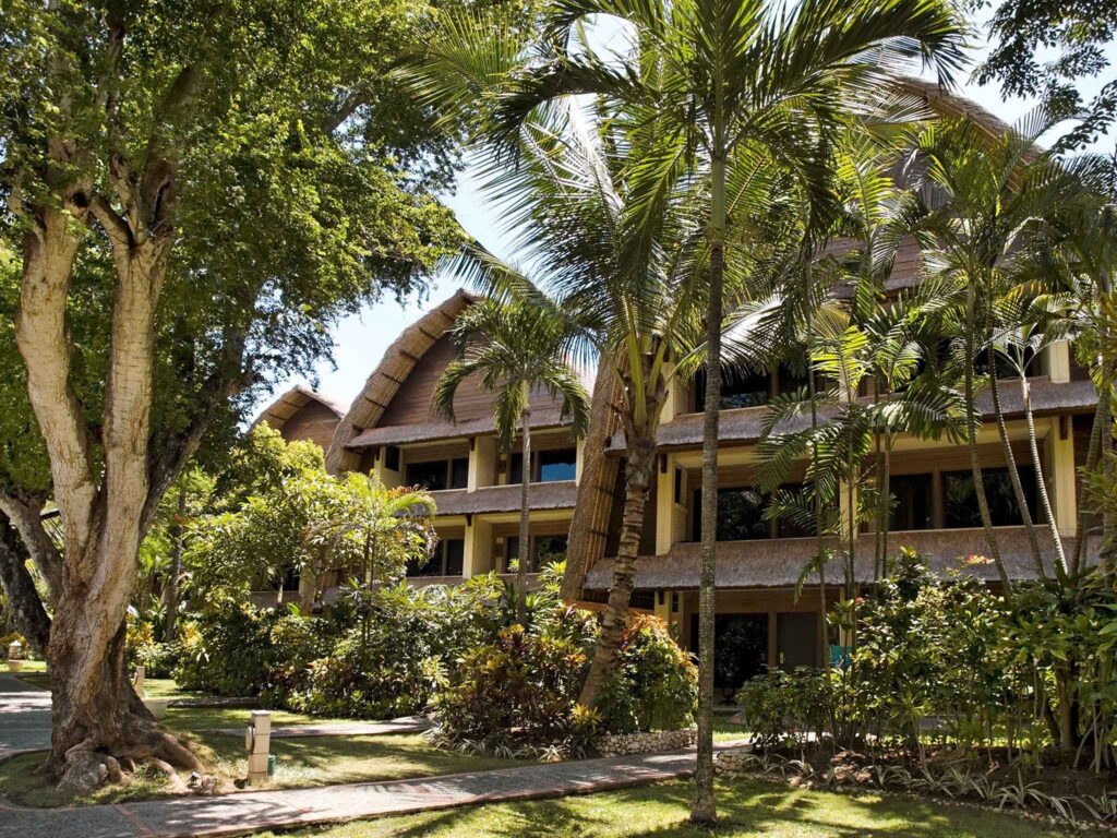 Exterior view of Mercure Resort Sanur in Bali, surrounded by tropical gardens and palm trees
