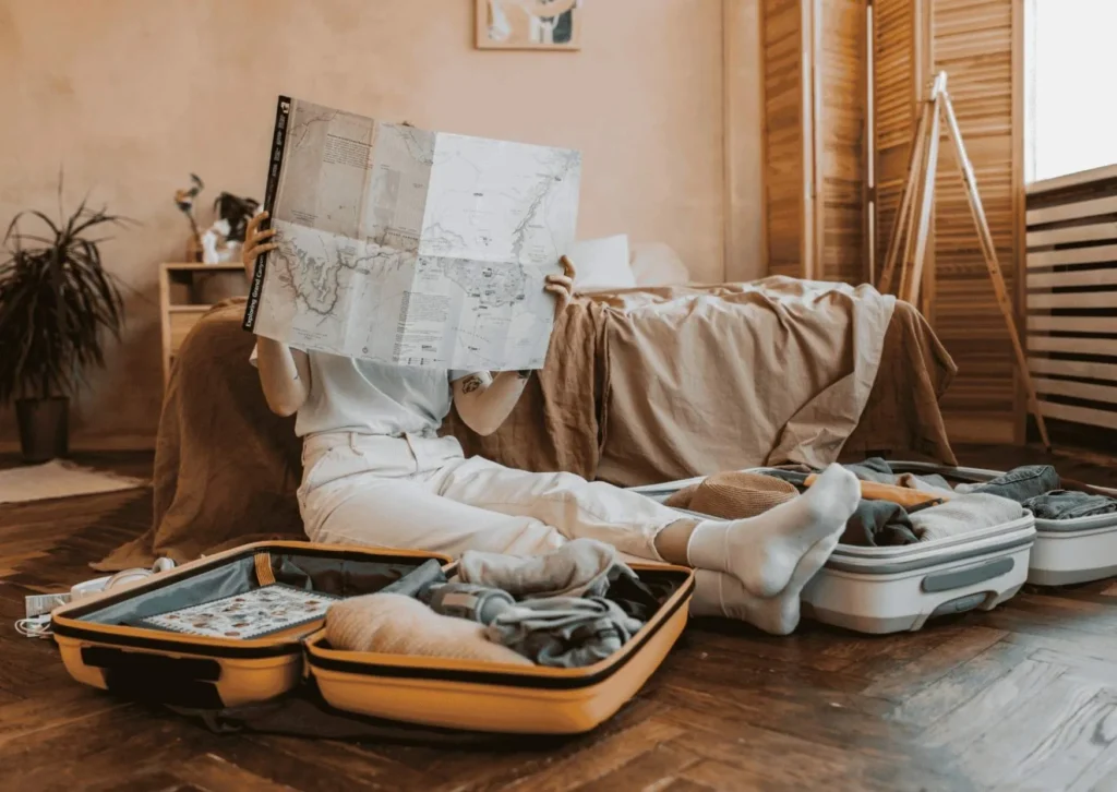 Bali YTT preparation – student planning with laptop, travel notebook and yoga props on the floor