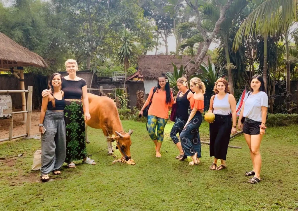 Yoga teacher training students spending time with Angelique the cow at Power of Now Oasis