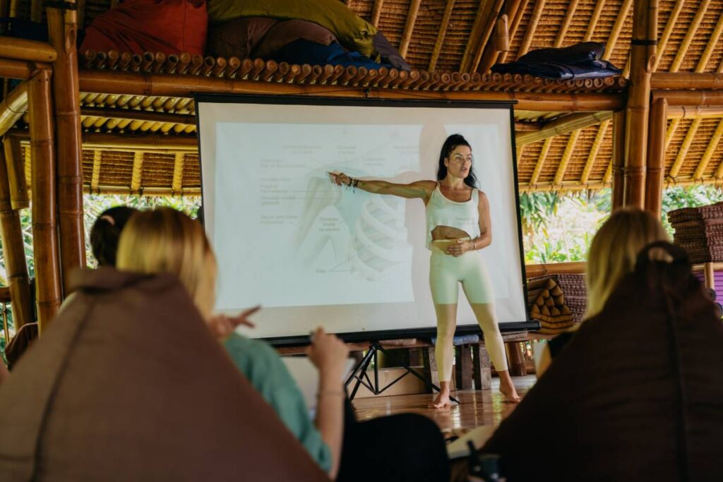 Anatomy teacher pointing at a diagram during yoga training