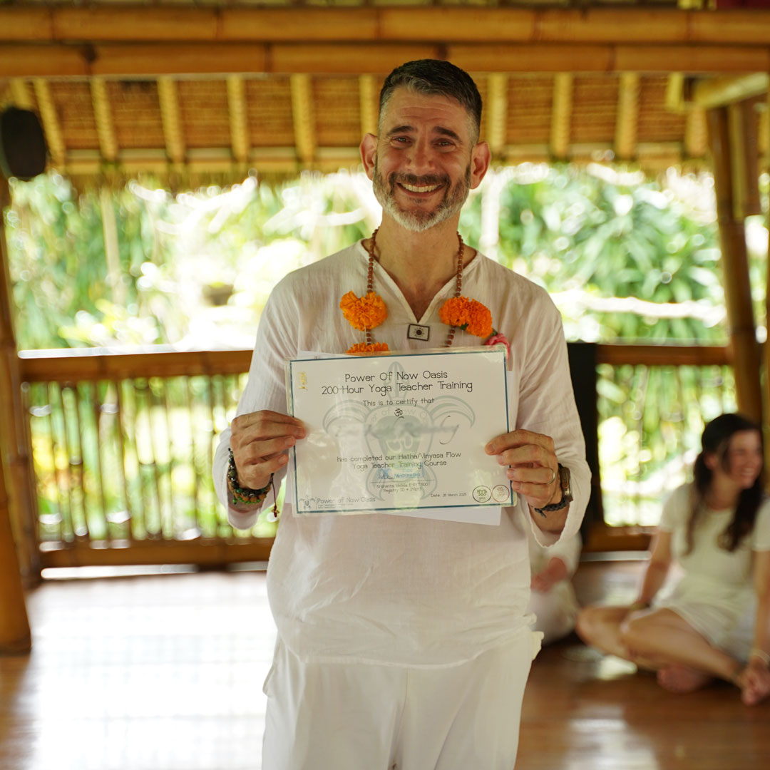 Yoga Teacher Training graduate at Power of Now Oasis in Bali holding certificate and smiling after completion ceremony